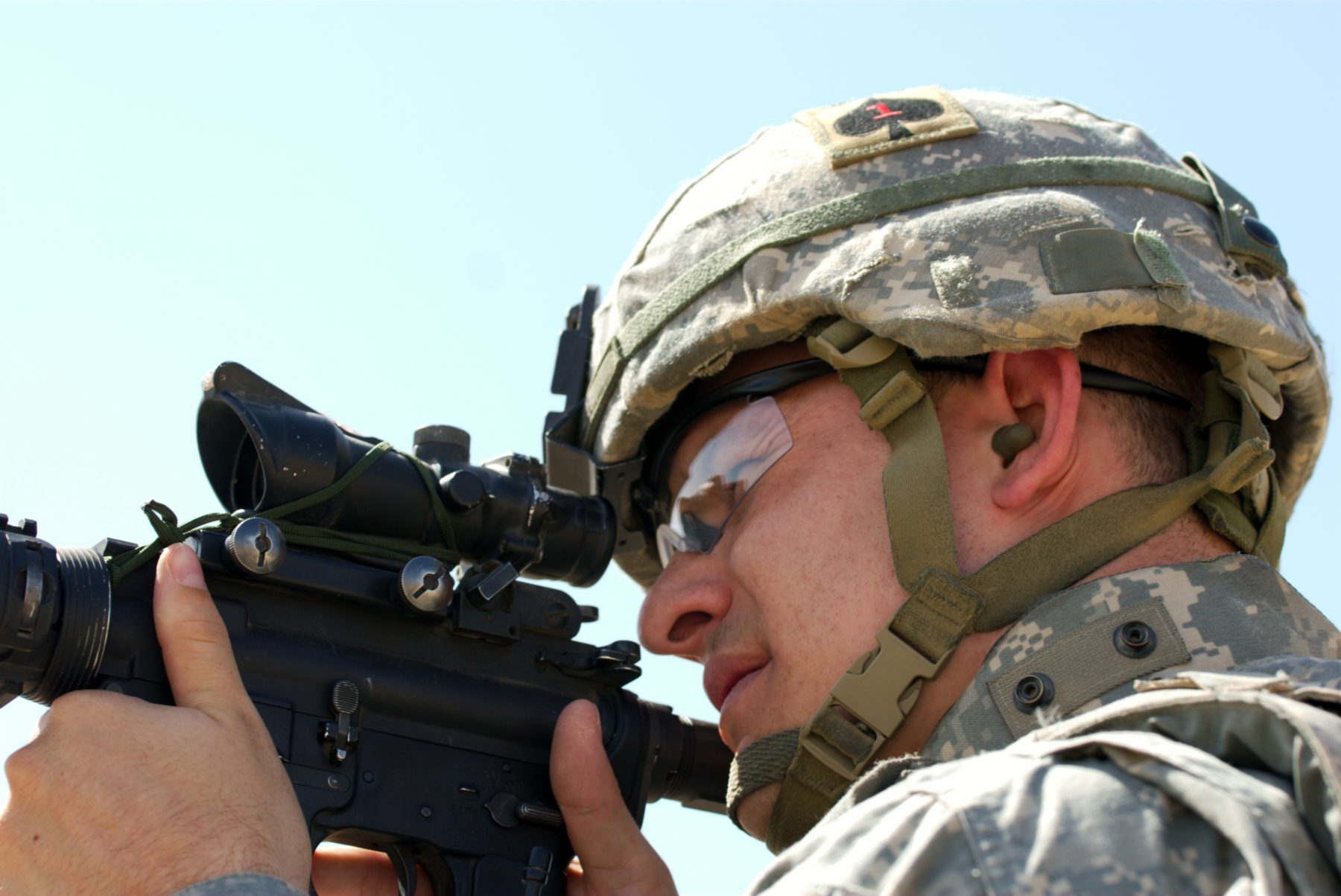 A man in combat wearing earplugs.