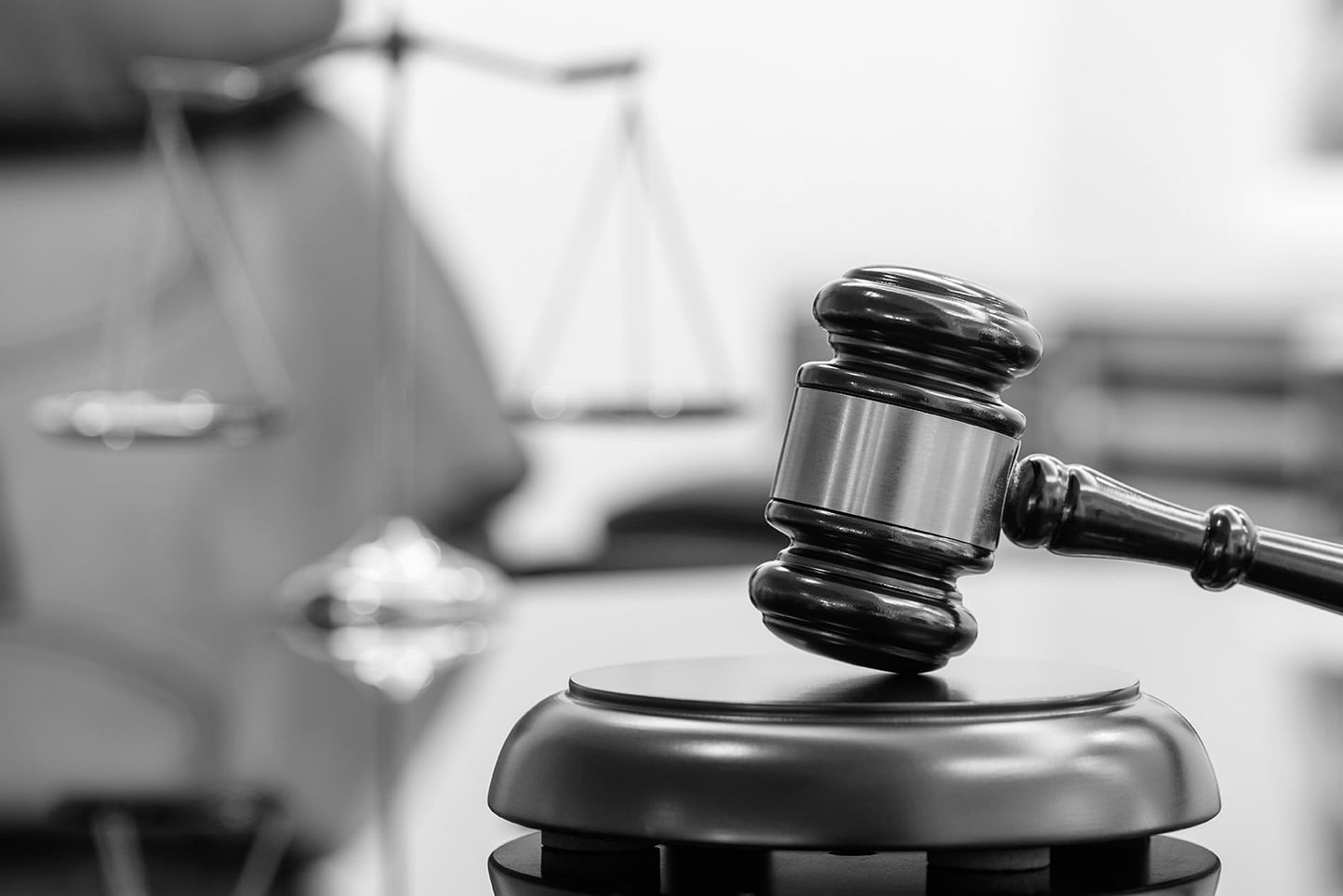 A judge’s gavel with a scale in the background