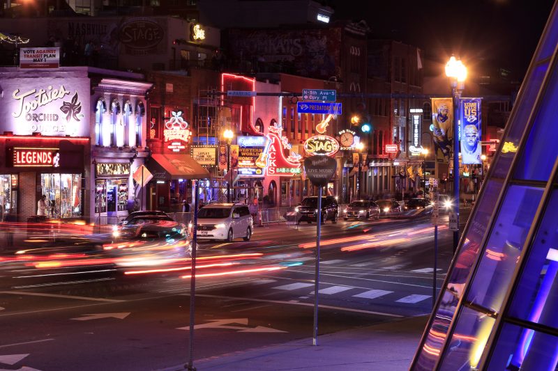 Tourists travel through the streets of downtown Nashville at night.